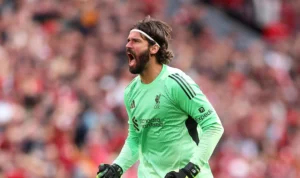 BOLAZOLA – Melatih suasana tim yang sempat terguncang, Arne Slot kembali hadir di ruang konferensi pers dengan raut wajah lebih tenang dari beberapa hari sebelumnya. Liverpool memang tengah menjalani pekan yang penuh tekanan. Mereka mencatat kekalahan 0-3 dari Nottingham Forest di Liga Inggris, lalu dipukul 1-4 oleh PSV Eindhoven di Liga Champions. Dua hasil itu membuat ruang ganti The Reds terasa memanas, sekaligus menempatkan Slot dalam sorotan tajam. Namun jelang lawatan ke markas West Ham akhir pekan ini, sang pelatih membawa satu kabar yang setidaknya bisa menarik napas lega bagi pendukung Liverpool. Yaitu soal kondisi para pemain yang sebelumnya mengalami cedera. Kembalinya Alisson, Harapan Baru di Bawah Mistar Yang pertama, sang manajer, Arne Slot memastikan bahwa Alisson Becker telah kembali berlatih penuh bersama tim. Sang kiper Brasil absen saat melawan PSV karena sakit, memaksa Giorgi Mamardashvili tampil sebagai starter. Kembalinya Alisson tentu menjadi dorongan besar bagi Liverpool yang tengah rapuh secara defensif. “Ali sudah berlatih lagi hari ini, jadi kami berharap dia tersedia untuk akhir pekan,” ujar Slot dengan nada optimistis. Stabilitas dan kepemimpinan Alisson dianggap sangat krusial, terlebih Liverpool baru saja kebobolan tujuh gol dalam dua laga. Kehadiran sang penjaga gawang andalan bisa menjadi fondasi awal untuk mengembalikan ketenangan di lini belakang. Menunggu Kondisi Wirtz & Ekitike Di sisi lain, dua pemain yang juga absen di tengah pekan, Florian Wirtz dan Hugo Ekitike, masih perlu pemantauan lebih lanjut. Slot mengonfirmasi bahwa Wirtz hampir menuntaskan proses pemulihan dan berpotensi kembali berlatih pada Sabtu. “Besok hari terakhir rehabilitasinya. Jika lancar, dia bisa berlatih bersama tim,” jelas Slot. Dua kekalahan beruntun di Liga Inggris membuat Liverpool, yang berstatus juara bertahan, terlempar ke papan bawah setelah 12 pekan. Kembalinya pemain-pemain kunci memang memberi harapan, namun Slot tetap membutuhkan reaksi cepat yakni kemenangan dari anak-anak asuhnya. Pertandingan menghadapi West Ham kini jadi ujian penting, karena tidak hanya menjaga asa ke empat besar Liga Inggris. Tapi juga pembuktian dari Liverpool, sebagai juara bertahan, apakah masih punya mental bangkit dari keterpurukan?